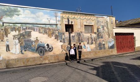 Друзья в старом городе перед настенным панно, на котором изображён момент посещения Евпатории в 1916 г. Российским императором Николаем Вторым