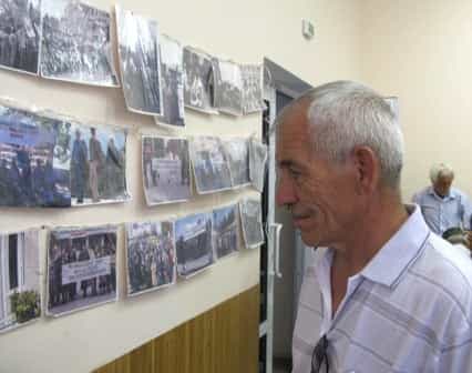 Эмир Меджитов рассматривает экспозицию фотографий, подготовленную активным участником тех событий Муратом Военным